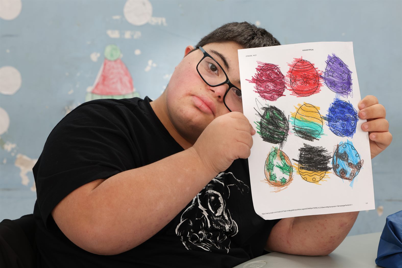 Ragazzo che mostra un disegno colorato durante un laboratorio